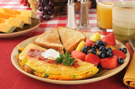 A Western Omelet with fresh fruit and berries for breakfastの写真素材