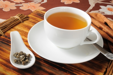 A cup of hot tea with a sample spoon with Jasmine tea pearlsの写真素材
