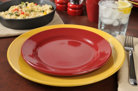 A dinner table setting with a skillet of garlic shrimp risotto in the backgroundの写真素材