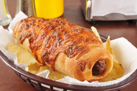 A thick weiner wrapped in pastry and topped with melted cheeseの写真素材