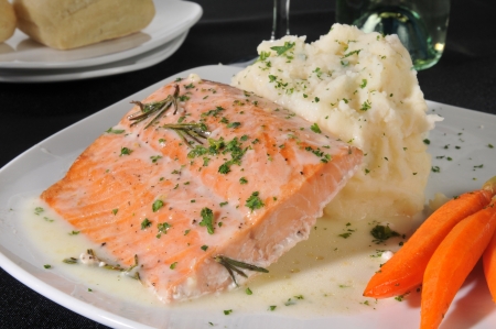 Closeup of a plate of baked salmon with carrots and mashed potatoes with country gravyの写真素材
