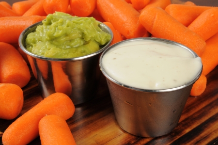 Fresh baby carrots with ranch dressing and guacomoleの写真素材