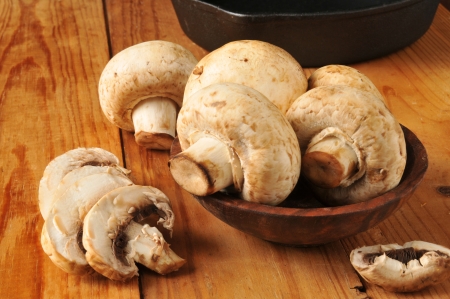Fresh sliced mushrooms with a cast iron skillet in the backgroundの写真素材