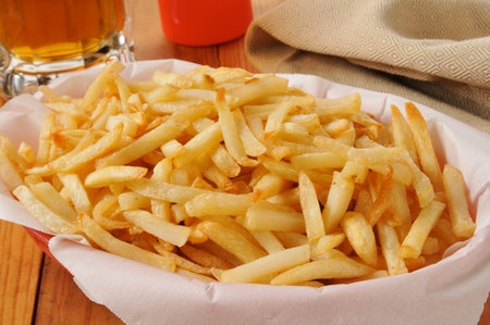 A basket of french fries and a mug of beer
