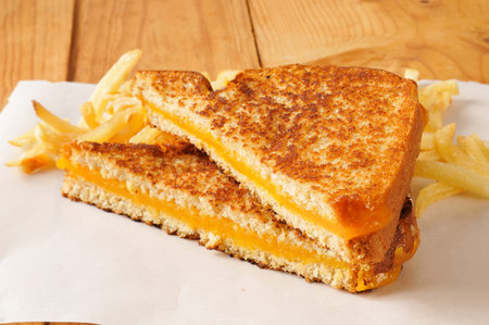 A grilled cheese sandwich on a rustic wood tableの写真素材