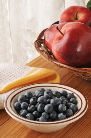 Fresh blueberries in a small bowl by the kitchen windowの写真素材