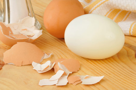 A hard boiled brown egg with a shaker of aslt