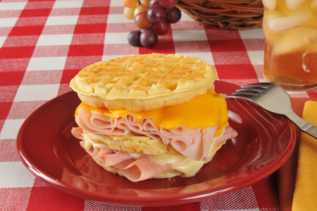 A Monte Christo sandwich with ham, turkey, American and Swiss cheese on a waffleの写真素材