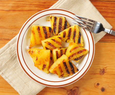 Grilled pineapple slices on a plate, shot from a high angle viewの写真素材