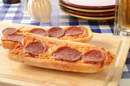French bread pizza on a cutting board and a mug of beerの写真素材