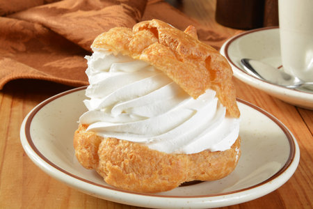 A large gourmet cream puff on a rustic wooden table