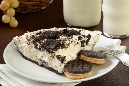 A slice of cookies and cream pie with a bottle of milkの写真素材