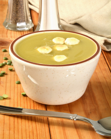 A cup of organic split pea soup with condimentsの写真素材