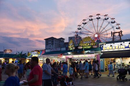 OCEAN CITY, NEW JERSEY/USA - JUNE 27, 2019: Crowds of tourists enjoying the iconic Ocean City Boardwalk during a colorful sunsetのeditorial素材