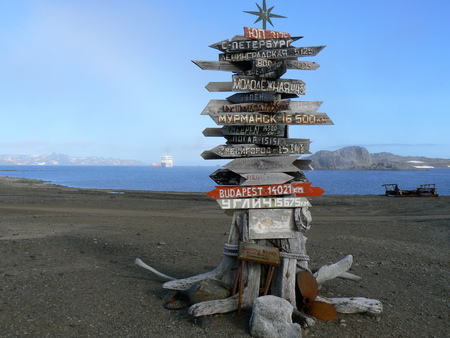 A signpost on the Antarctic peninsula shows distances to various points around the world.の写真素材