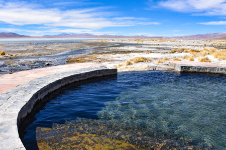 Laguna y Termas de Polques hot springs pool with the Salar de Chalviri in background, Reserva Eduardo Avaroa, Potosi, Boliviaの写真素材