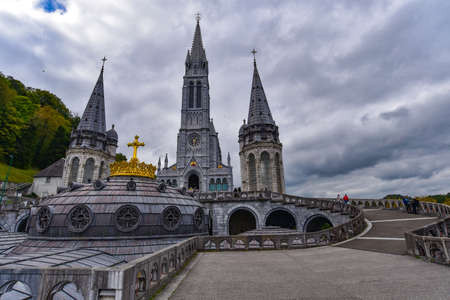 Lourdes, France - 9 Oct 2021: Gold gilded cross atop the dome of the Basilica of Our Lady of the Rosary in Lourdesのeditorial素材
