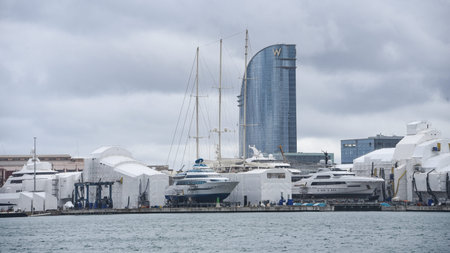 Barcelona, Spain - 24 Nov, 2021: Superyachts and boats in sailing in Barcelona shipyard with the hotel W in the backgroundのeditorial素材