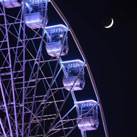 San Sebastian, Spain - Dec 30, 2021: Ferris Wheel illuminations & the Moon over La Concha Bayのeditorial素材