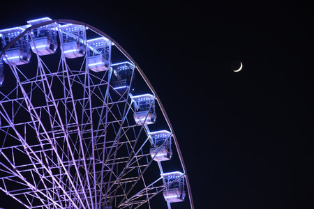 San Sebastian, Spain - Dec 30, 2021: Ferris Wheel illuminations & the Moon over La Concha Bayのeditorial素材