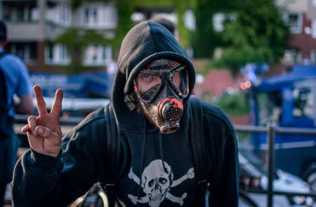 Fishmarket Hamburg, Germany - July 6, 2017: Single masked protester showing finger signのeditorial素材