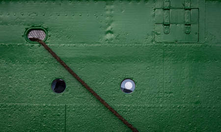 Old round porthole on green ship deck with ropesの写真素材