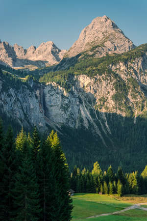 Scenic panoramic view of idyllic alpine mountain peak landscape on a beautiful sunny day with blue sky in summer. Cliff and waterfall.の写真素材