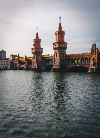 The Oberbaum Bridge, German Oberbaumbrucke and River Spree in Berlin, Germany. Subway going over the...