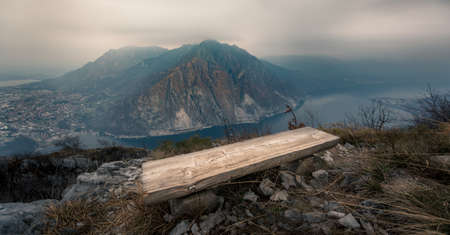 Lonely empty wood bench on mountain overlooking Lake Como, Italyの写真素材