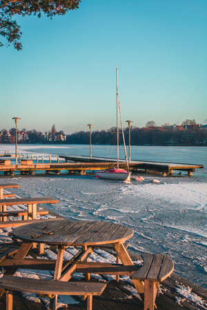 Sailing boat, yacht waiting for the summer at frozen port, Hamburg, Outer Alster in Winterの写真素材