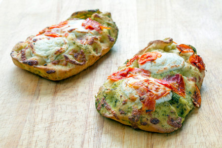 Sun dried tomatoes and goats cheese focaccia on a wooden cutting board