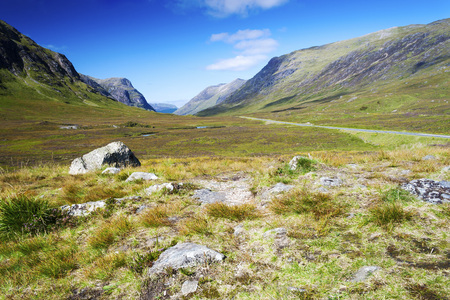 View of mountain ranges in the Scottish Highlands from Glen Coe Valley on a clear summer dayの写真素材
