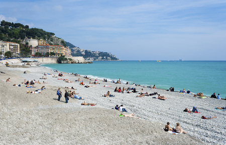 Nice, Cote d'Azur, France - May 10, 2010: People sunbathing on a hot summer day on the beach along the Promenade des Anglais in Nice Franceのeditorial素材