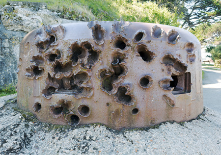 World war two military bunker in Port des Sablons Saint Malo with heavy damage from attack and remaining shell lodged in placeの写真素材