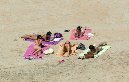 Saint Malo, Brittany, France - July 7, 2018: Five attractive young females sunbathing and relaxing on Saint Malo beach on a hot summer dayのeditorial素材