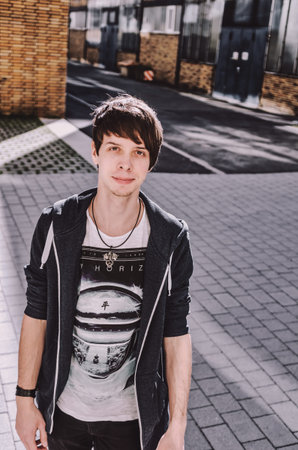 Young adult rock musician, looking at camera, singer wearing a blue sweatshirt, t-shirt, standing,...