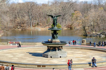 Bethesda Fountain with Angel of the Waters Sculpture with people walking and standing around the fountain, lake in the background Central Park New York during winter, horizontalのeditorial素材
