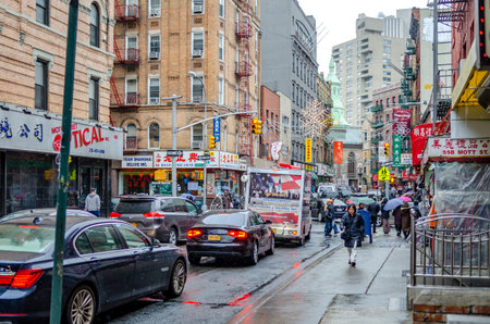 Traffic Jam at China Town New York City, red traffic light, rainy winter day with people walking with umbrellas on the sidewalk of the street, during rainy winter day with overcast, horizontalのeditorial素材
