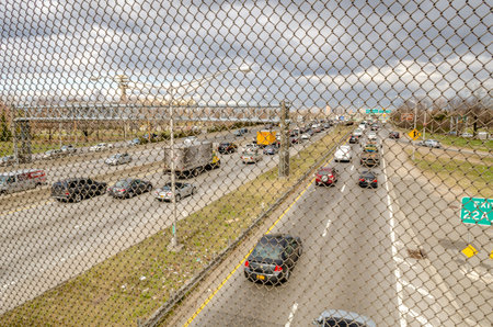 Highway in Queens with metal fence in the front, New York City near Flushing-Meadows-Park during...