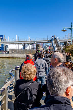People, tourist waiting in line in front of the entrance of Intrepid Sea-Air-Space Museum, New York City during sunny winter day with clear sky, verticalのeditorial素材