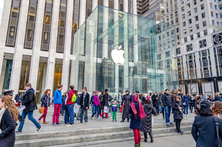 Apple Store, Manhattan, Glass Cube with white apple logo, white angle shot, New York City with lots of people walking in front during sunny winter day, horizontalのeditorial素材