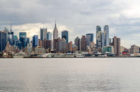 View of Manhattan Skyline, New York City with Empire State Building, Hudson river in front during cloudy winter day, horizontalのeditorial素材