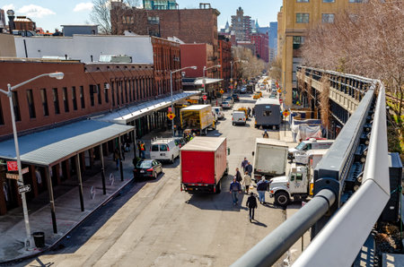City Street in Chelsea with lots of traffic, trucks parked on the street, view from the High Line...