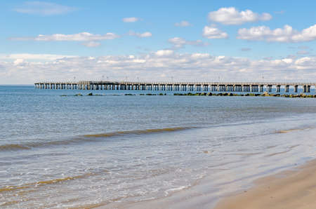 Pat Auletta Steeplechase Pier at Coney island Beach, no people, Brooklyn, New York City, view from the side, wide angle, during winter day with cloudy sky, horizontalの写真素材