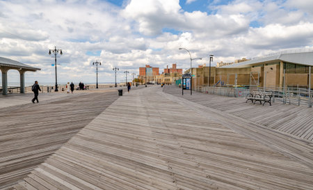 Beach Promenade at Coney island, Brooklyn with People walking around, Residential Buildings in the...