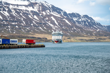 AIDA Bella Cruise Ship at the fjord of Seydisfjordur, Iceland, view from the distance with port in front and snow mountain range in the backの写真素材