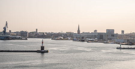 Cityscape Skyline of Aarhus, Denmark in the evening with lighthouse in front and sea, sunset...
