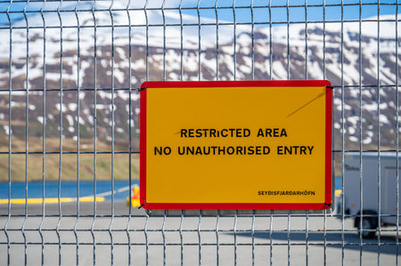 Yellow Restricted Area No Unauthorized Entry Sign at the Port of Seydisfjordur, Iceland