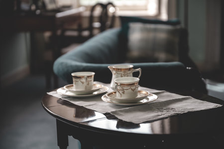 Tea cups on an old wooden table with couch indoors at Skaill House, Orkney Island, Scotlandの写真素材