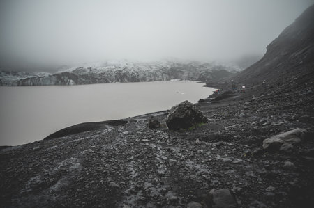Solheimajokull Glacier, view from the distance during foggy weather, tourists hiking in the distance, wide angle shot, Icelandの写真素材